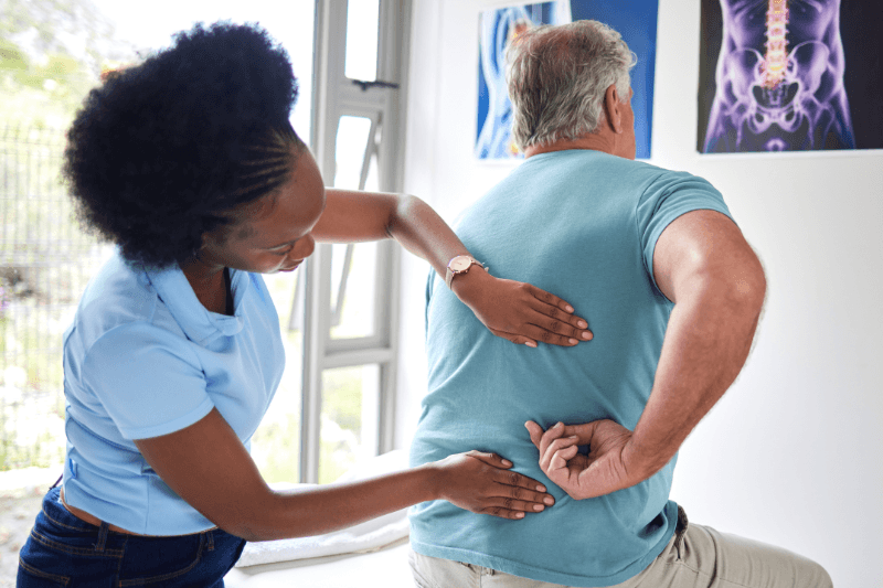 A Spine Expert Examines a Patient for Possible Spinal Fusion Surgery in South Florida